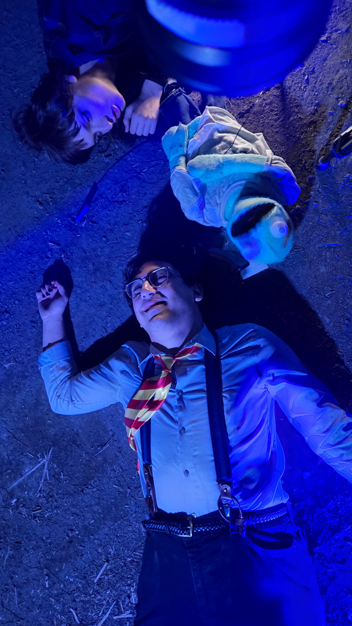 Dom is laying on the ground laughing, with Chet laying right beside him, candice can be seen puppeting chet right above him.